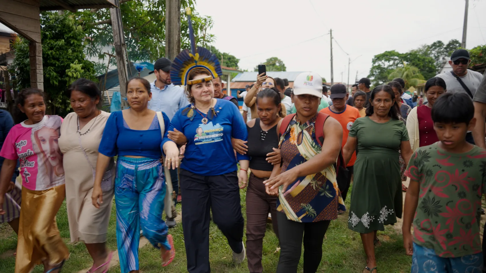 Professora Maria caminhando com moradores de uma comunidade