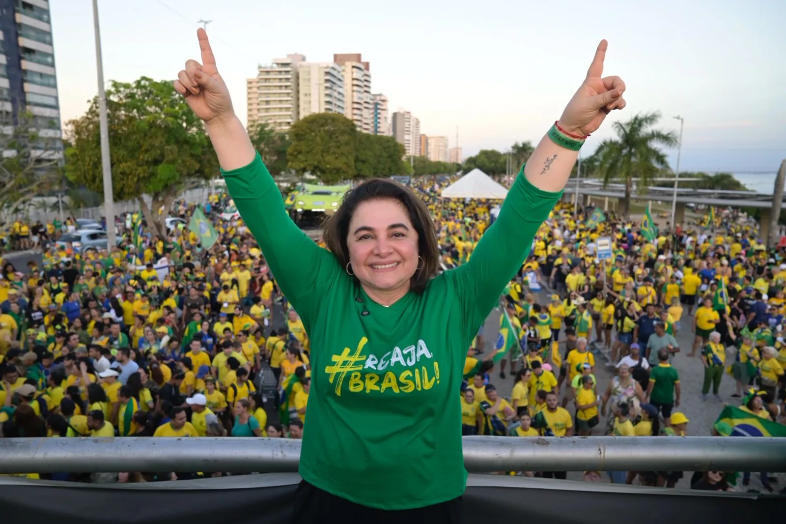Professora Maria de braços erguidos diante da multidão