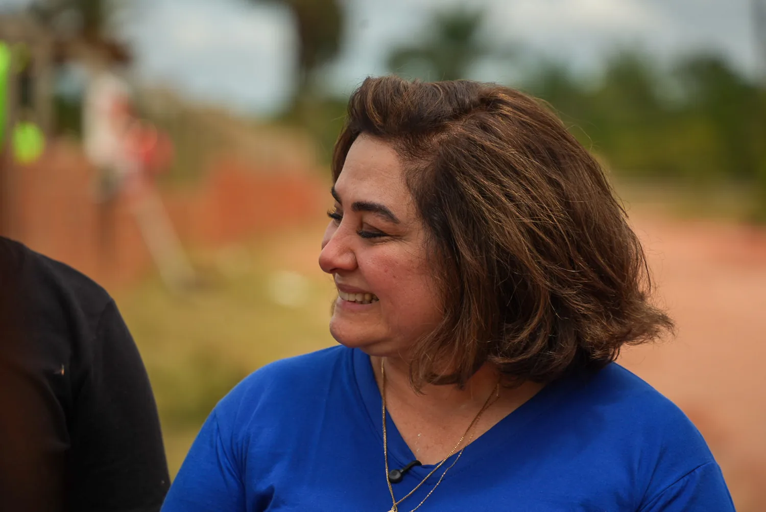 Professora Maria sorrindo, de perfil